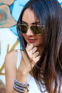 Close-up of beautiful young woman wearing sunglasses while standing outdoors