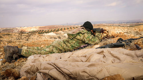 Full length of soldier observing field