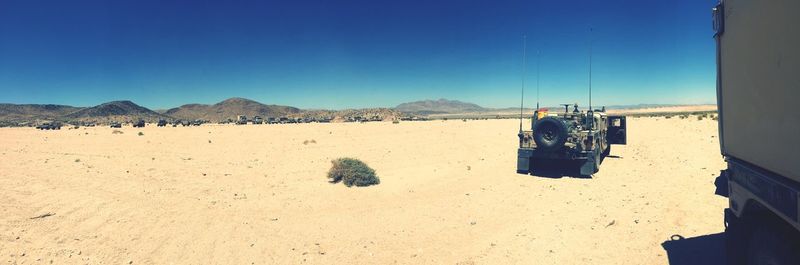 Panoramic view of desert against clear blue sky