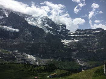 Scenic view of mountains against cloudy sky