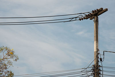 Low angle view of electricity pylon against sky