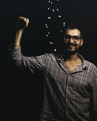 Portrait of smiling young man wearing eyeglasses at night