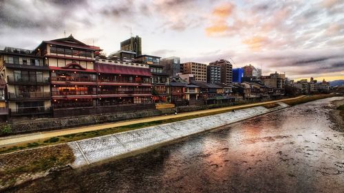 River amidst buildings in city against sky