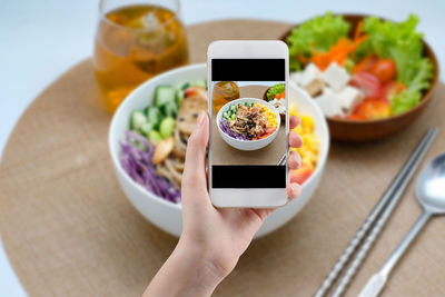Cropped image of hand holding food served on table