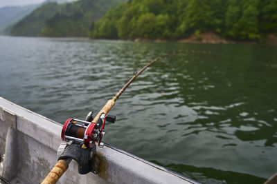 Fishing rod on railing by lake