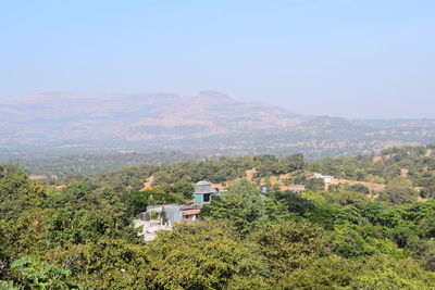 Scenic view of trees and buildings against sky