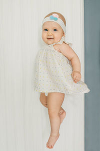 Portrait of smiling girl levitating against wall