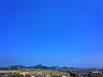 View of cityscape against clear blue sky