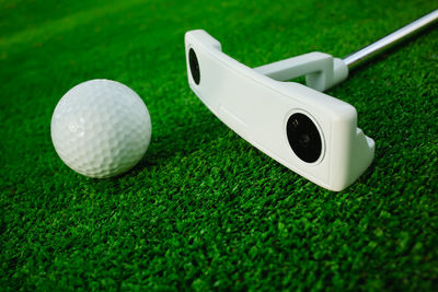 Close-up of golf ball and club on grass