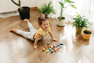 A charming little girl sculpts from colored plasticine on the floor. home schooling.