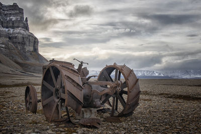 Old abandoned truck on field against sky