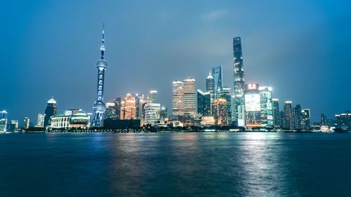 Illuminated buildings in city at waterfront