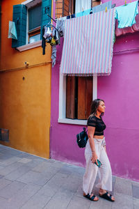 Full length of woman standing against building