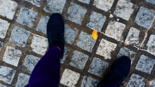 Low section of person standing on tiled floor