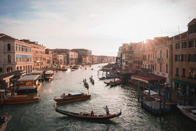 Boats in canal amidst buildings in city