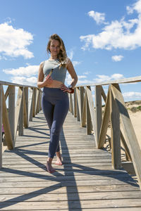 Rear view of woman walking on boardwalk