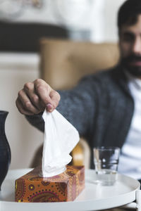 Young patient removing tissue from box at table