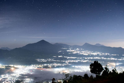 Aerial view of illuminated city against sky at night