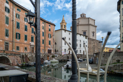 Canal amidst buildings against sky in city