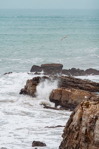 Scenic view of rock formation in sea against sky