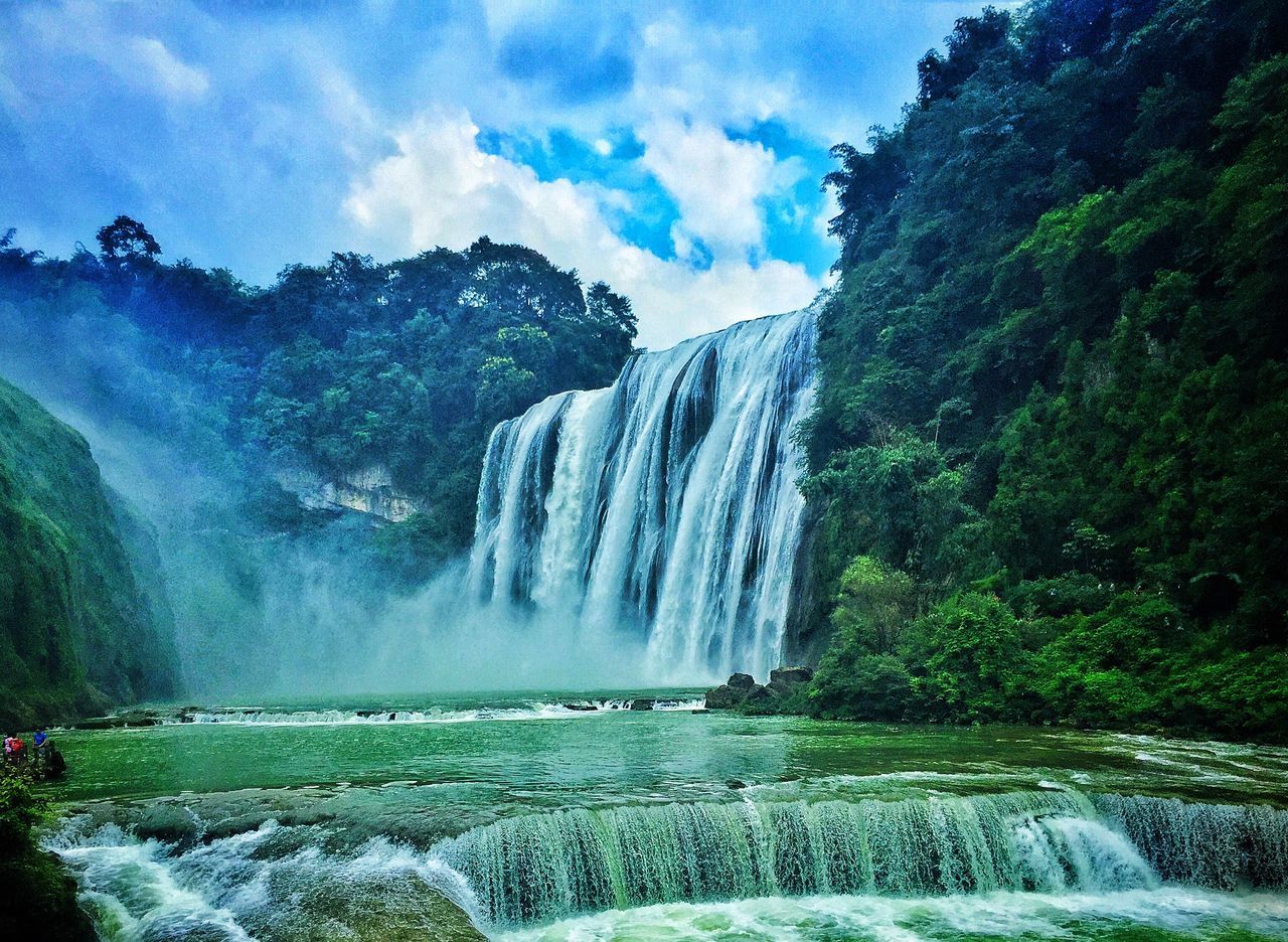 waterfall, scenics, water, beauty in nature, sky, nature, tranquil scene, cloud, idyllic, flowing water, flowing, green color, blue, cloud - sky, tranquility, outdoors, day, non-urban scene, power in nature, green, lush foliage, mountain, majestic, falling water, no people