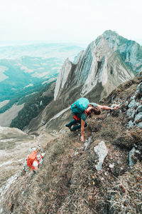 People on rocks by mountains