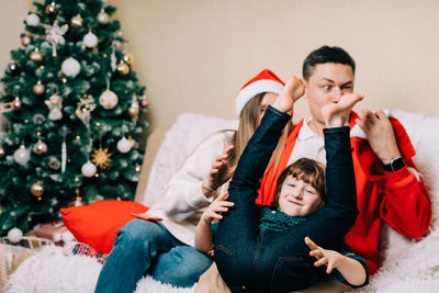 Cheerful family sitting on sofa during christmas