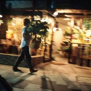 Blurred motion of people walking on road at night