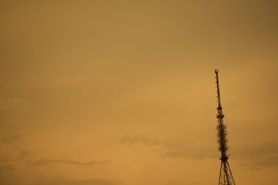 Low angle view of communications tower against sky during sunset