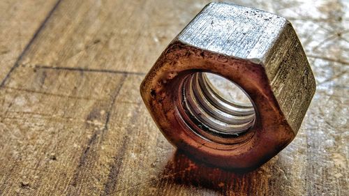 High angle view of rusty metallic bolt on table