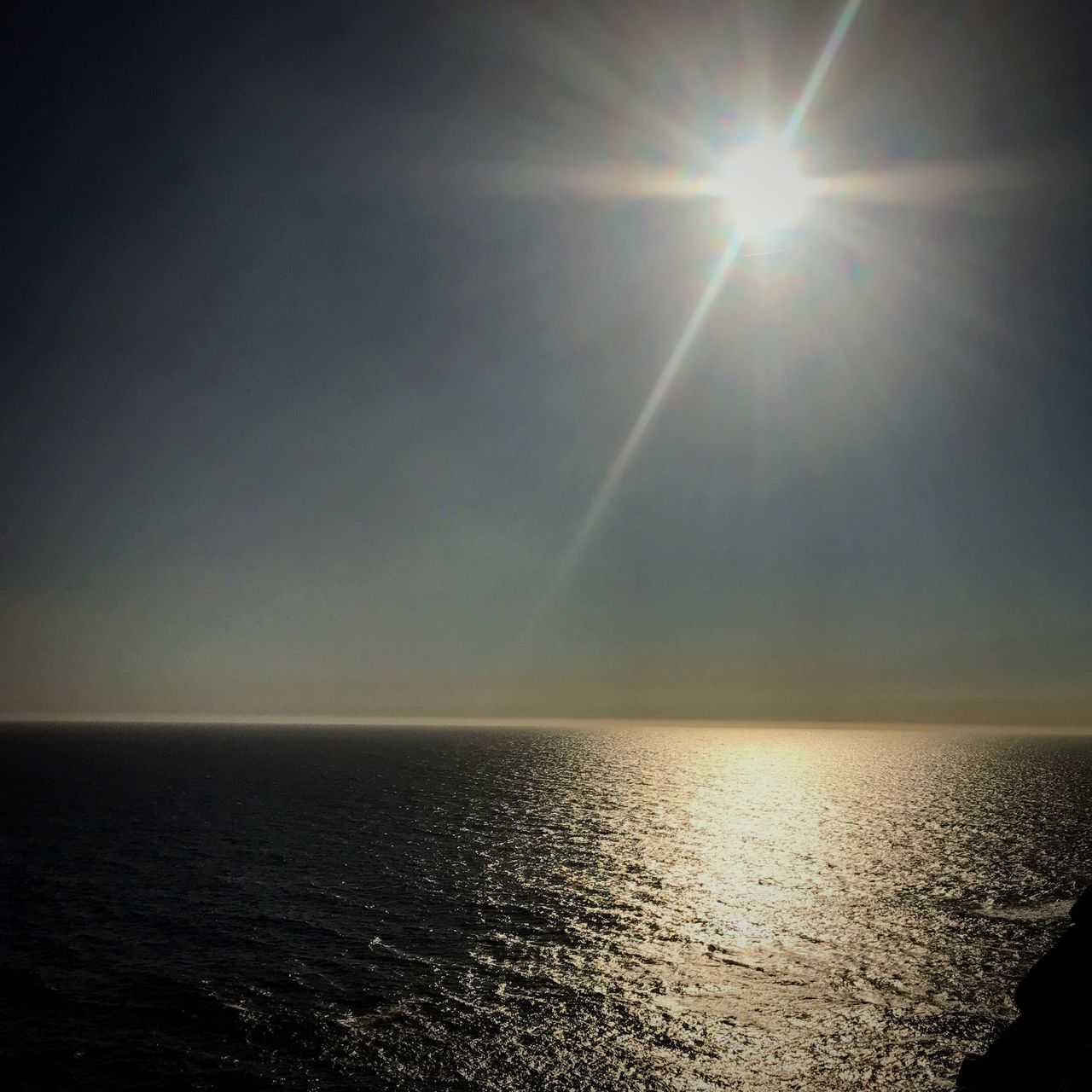 SCENIC VIEW OF SEA AGAINST BRIGHT SUN IN SKY