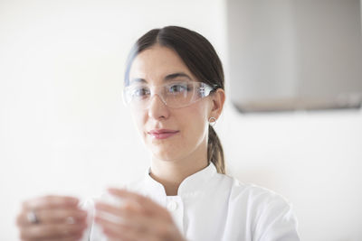 Scientist female with lab glasses, tablet and sample in a lab