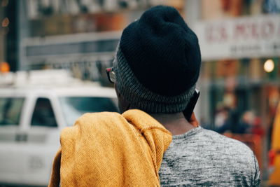 Rear view of man wearing hat in city