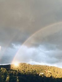 Rainbow over landscape against sky