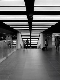 People in illuminated corridor