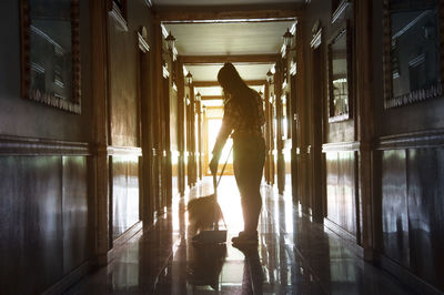 Rear view of woman walking in corridor