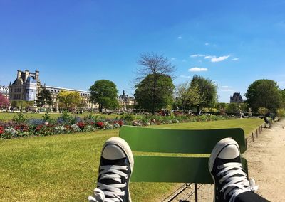 Low section of person on chair against sky at park