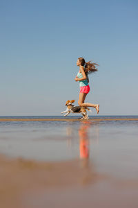 Rear view of woman swimming in sea against clear sky