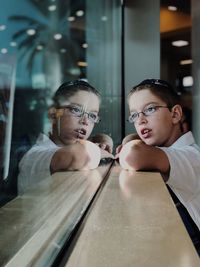 Portrait of boy with reflection in glass