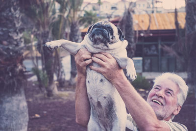 Senior man holding pug