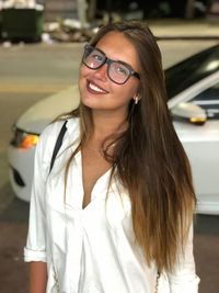 Portrait of smiling young woman standing on road