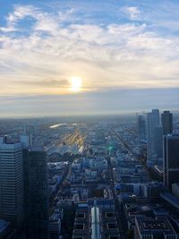 Aerial view of buildings in city against sky during sunset