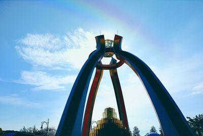 Low angle view of ferris wheel against blue sky