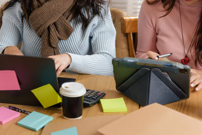 Midsection of woman using laptop on table