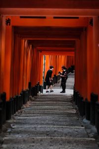 Rear view of people walking in corridor of building