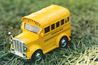 Close-up of yellow toy school bus on grass