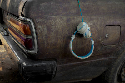 Close-up of headphones hanging on abandoned car