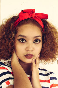 Portrait of young woman against white background