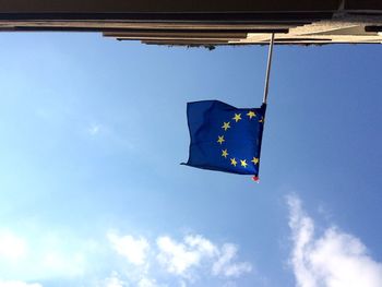 Low angle view of flag against blue sky