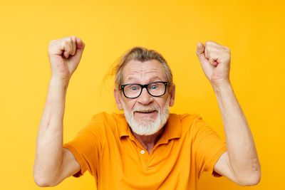 Portrait of senior man against yellow background